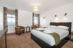 a bedroom with a large bed with towels on it at Hillside Dunbar in Dunbar