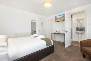 a white bedroom with a bed and a sink at Hillside Dunbar in Dunbar