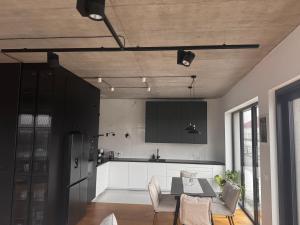a kitchen with a table and chairs in a room at Penthouse in Nowy Sącz