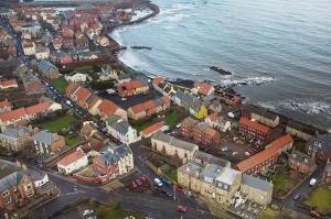 an aerial view of a city next to the water at Hillside Dunbar in Dunbar