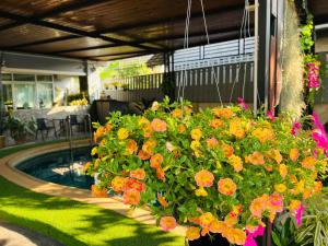 a garden with flowers and a swimming pool at Chean-Chean House in Chiang Rai
