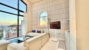 a living room with a couch and a large window at FORESTE Haus 포레스테하우스 in Seoul