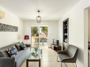 a living room with a couch and a table at Mythical Sands CB04 in Paralimni