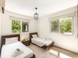 two beds in a room with two windows at Mythical Sands CB04 in Paralimni
