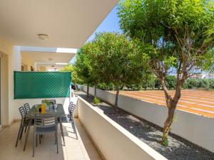 a table and chairs on a balcony with trees at Mythical Sands CB04 in Paralimni