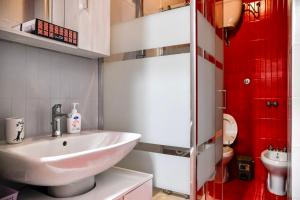 a bathroom with a white sink and a red shower at Mary Jungle in Porto SantʼElpidio
