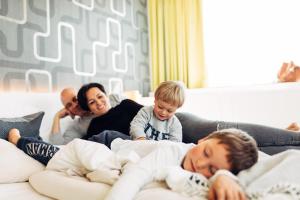 a family laying on a couch with their children at harry's home Wien hotel & apartments in Vienna