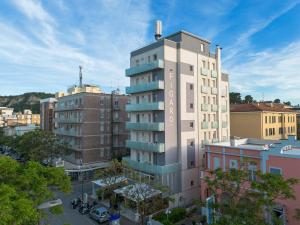 a tall building in a city with buildings at Amadei Hotel Figaro & Apartments in Pesaro