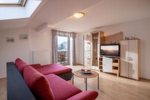 a living room with a couch and a tv at Bauernhof Grafenhof in Ebbs