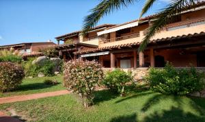 a house with a palm tree in front of it at Appartamenti sul mare in Santa Marinella