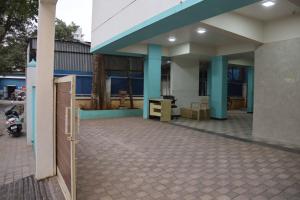 a building with blue columns and a patio at Hotel krishnasai in Pune