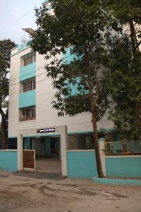 a building with a tree in front of it at Hotel krishnasai in Pune