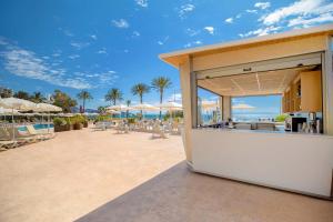 a restaurant with chairs and umbrellas on a beach at Hotel Servigroup Trinimar in Benicàssim