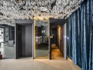 a hallway with two doors and a chandelier at CHECK inn Taichung Liming in Taichung
