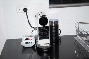 a coffee maker with a phone on a table at The Arches-Beautiful 3-Bedroom Family Stay Near Adelaide Oval, City Events and Amazing Dining in North Adelaide