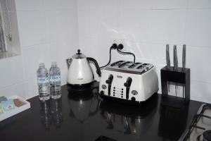 a toaster and bottles of water on a table at The Arches-Beautiful 3-Bedroom Family Stay Near Adelaide Oval, City Events and Amazing Dining in North Adelaide +15 photos