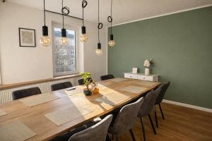 a dining room with a large wooden table and chairs at LMB stays in Recklinghausen