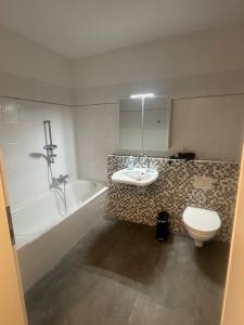 a bathroom with a sink and a tub and a toilet at LMB stays in Recklinghausen