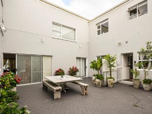 a patio with a table and some potted plants at Lieflappie Seaview Stilbaai 400m to the beach in Stilbaai +3 photos