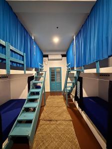 a room with two bunk beds with blue walls at Hostel by Sri villa polwatta in Weligama