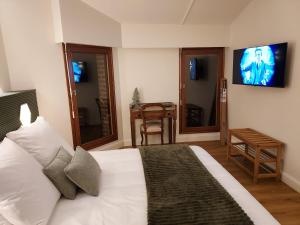a bedroom with a bed with a tv on the wall at A L'Esquirot in Gabarret