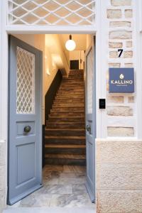 a hallway with a blue door and stairs at KALLINO Island Suites in Ermoupoli