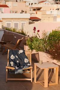 a chair and a table on a balcony at KALLINO Island Suites in Ermoupoli