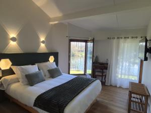 a bedroom with a large bed in a room with a window at A L'Esquirot in Gabarret +46 photos