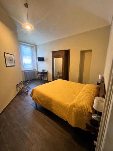 a bedroom with a bed with a yellow bedspread at La Fornace in Garessio
