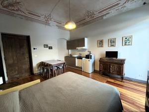 a living room with a kitchen with a table and a bed at La Fornace in Garessio