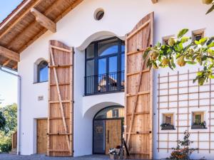 a house with wooden doors and windows at Sailerhof Gramminger in Taching am See +6 photos