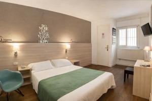 a hotel room with a bed and a blue chair at Hotel Carbonell in Llança +135 photos