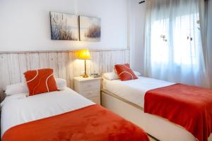 a bedroom with two beds with red and white sheets at Casa Alicia Altea By DelucaCo in Altea