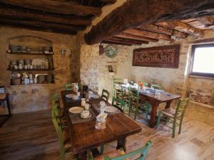 a dining room with wooden tables and green chairs at B&B Manca1Fiorino in Spoleto