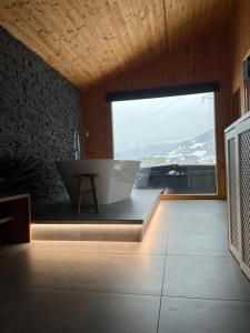 a bathroom with a tub and a large window at Hillside Chalet Kreischberg in Sankt Lorenzen ob Murau