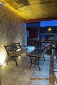 Un banco y una mesa en un patio. en Hosteria Kaiken Gregores, en Gobernador Gregores