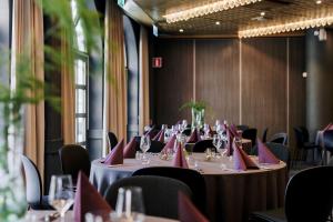 a row of tables in a room with red napkins at Scandic Star Sollentuna in Sollentuna +57 photos