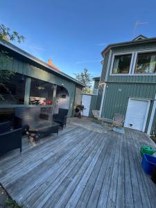 a large deck in front of a green house at Kråksjöviken in Västervik