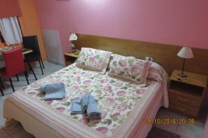 Un dormitorio con una cama con ropa y zapatos. en Hosteria Kaiken Gregores, en Gobernador Gregores
