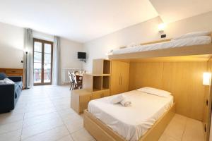 a bedroom with two bunk beds and a desk at Hostdomus - Mughetto Apartment in Pragelato