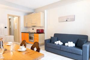 a living room with a blue couch and a table at Hostdomus - Mughetto Apartment in Pragelato