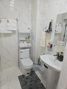a white bathroom with a toilet and a sink at Guest house 2 in Fergana