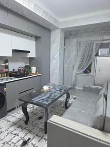 a kitchen with a table in the middle of a room at Guest house 2 in Fergana