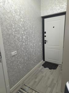 a room with a white door and a wooden floor at Guest house 2 in Fergana +1 photo
