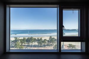 a window with a view of the beach at H-Avenue Hotel Yeongildae in Pohang