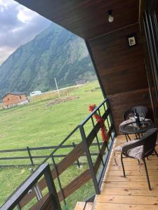 a balcony with a view of a field and mountains at Achkhoti Paradise in Kazbegi