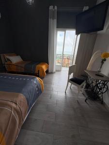 a bedroom with two beds and a table and a window at DAREB HOME vista mare in Agrigento