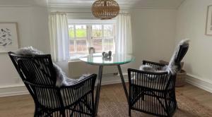 a dining room with a glass table and two chairs at Als Kloster in Sønderborg