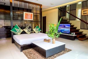 a bedroom with a white bed and a staircase at Peach Blossom Resort & Pool Villa - SHA Plus in Kata Beach