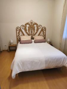 a bedroom with a large white bed with pillows at Ostal del Koï in Rabastens